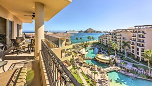 Un balcon avec coin salon extérieur et vue sur l’espace piscine du complexe hôtelier.