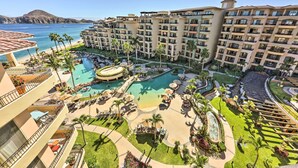 Un complexe hôtelier doté de plusieurs piscines, de palmiers et offrant une vue sur l’océan.