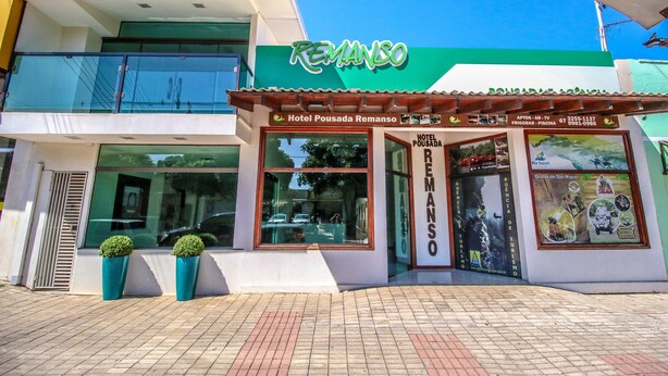 Un hotel llamado Remanso, con un letrero verde, un balcón y una entrada con azulejos.