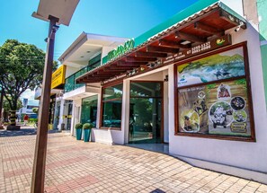 A hotel with a green sign, large windows, and a view of the surrounding area. - Pousada Remanso (Bonito)