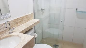 A bathroom with a sink, mirror, and shower.