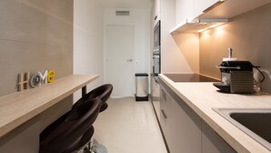 A modern kitchen with a built-in oven, a sink, and a countertop with a coffee machine.