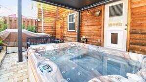 A wooden deck with a hot tub, a covered patio, and a door with a window. - Clear Creek Retreat - Take a trip to the mountains (Georgetown)