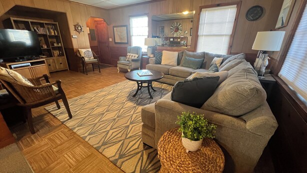 A cozy living room with a sofa, chairs, a coffee table, and a television. - Simply Adorable Beach House - Sleeps 9, Near Beach & Town (Seaside)