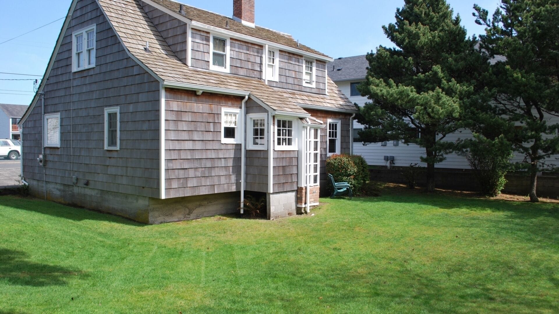 A two-story house with a sloped roof, a front porch, and a small front yard.