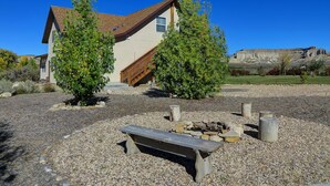 A house with a stone fireplace, wooden bench, and a staircase leading to the entrance.