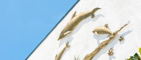 A white building with a dolphin mural on the side.