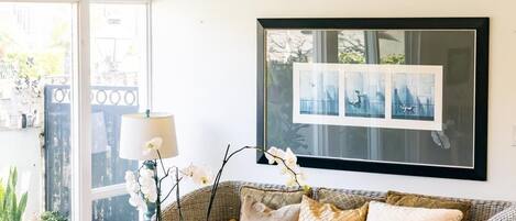 A living room with wicker furniture, a coffee table, and a framed picture on the wall.