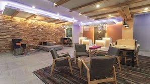 A modern lounge area with a mix of seating options, including sofas and chairs, and a central table. - La Quinta Inn & Suites by Wyndham South Jordan (South Jordan)