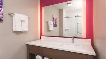 A bathroom with a white sink, a mirror with a red frame, and two towels hanging on a towel rack.