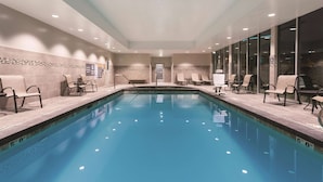 A large indoor swimming pool with lounge chairs and a tiled wall. - La Quinta Inn & Suites by Wyndham South Jordan (South Jordan)