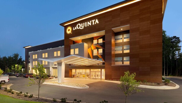 A modern hotel with a prominent 'La Quinta' sign, a covered entrance, and a landscaped driveway. - La Quinta Inn & Suites by Wyndham Rock Hill (Rock Hill)