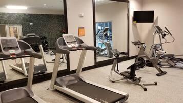 A gym with treadmills, an elliptical, and a spinning machine.