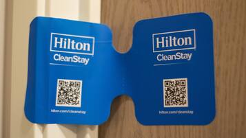 Zwei blaue Hilton CleanStay-Schilder mit QR-Codes und URLs.