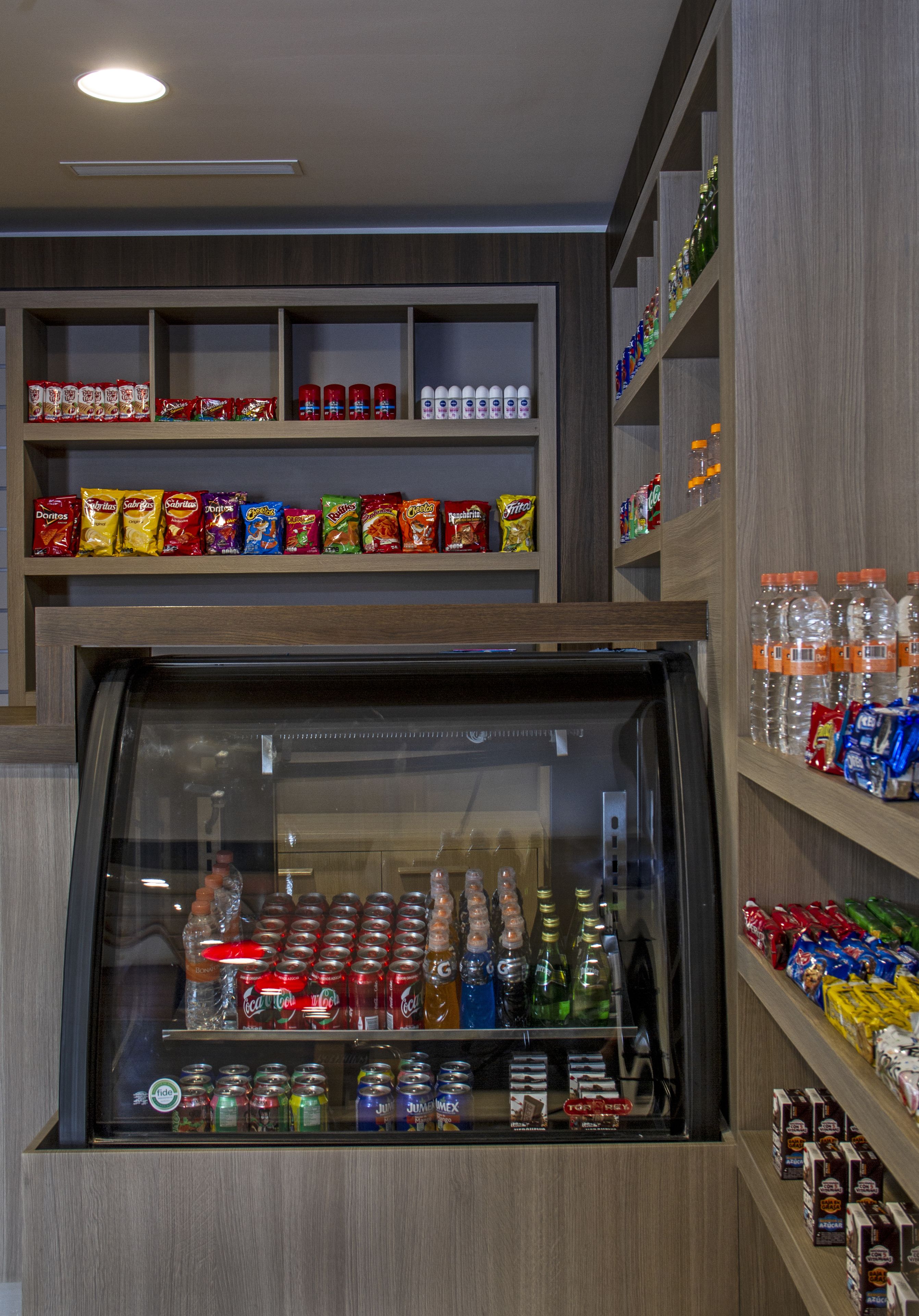 Uma geladeira expõe diversas bebidas e lanches.