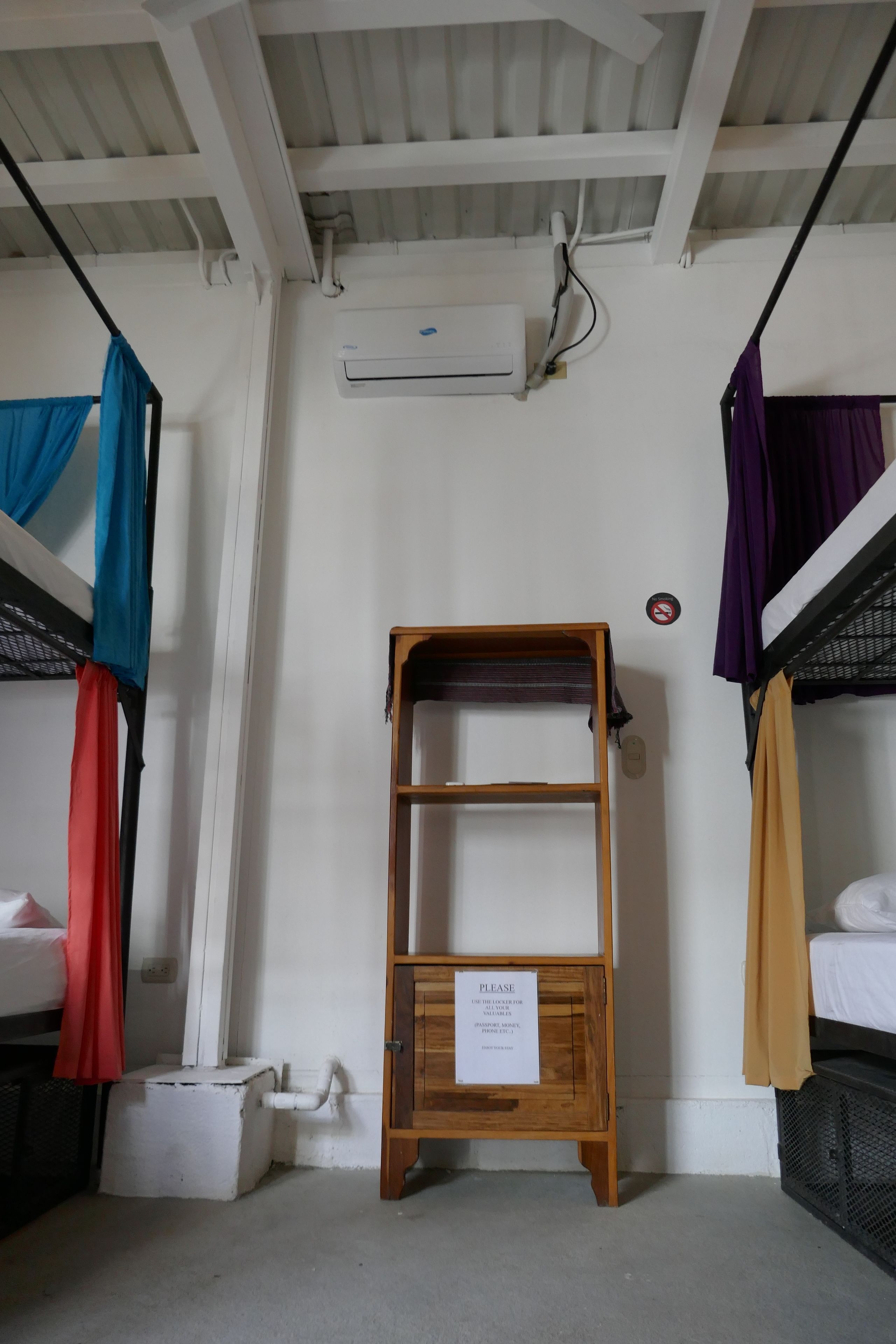 A bunk bed room with a wooden shelf unit and a sign.