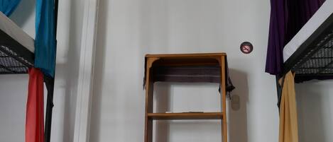 A bunk bed room with a wooden shelf unit and a sign.