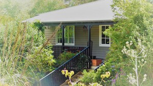 Ein Haus mit Veranda, Treppe und Garten.