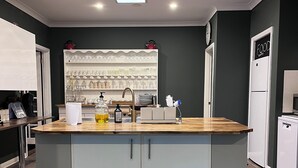 Eine moderne Küche mit einer zentralen Kochinsel, eingebauten Regalen und einem Kühlschrank.