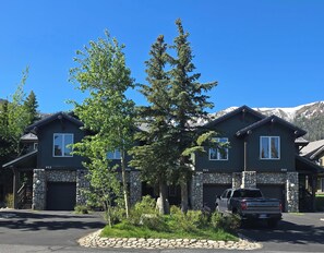 A two-story house with a stone facade, a driveway, and a parked truck. - Snowcreek Resort Vacation Rental 954 (Mammoth Lakes)