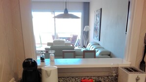 Una cocina con lavadora, tostadora y cafetera en la encimera.