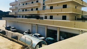 Un edificio de varios pisos con un estacionamiento al frente.