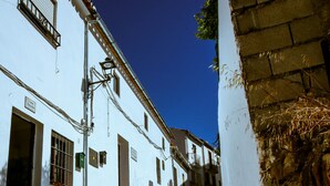 A narrow street with white buildings, a visible clock, and a sign that reads "Casa Recital". - The best terrace of the Serranía de Ronda, Emerald Pool: Casa Martijín (Jimera de Líbar)
