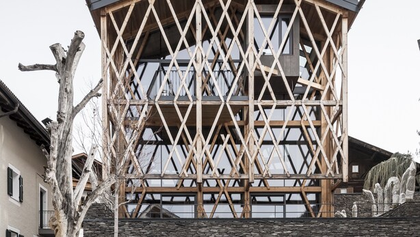 Un bâtiment moderne doté d’une façade en pierre et d’une structure en treillis de bois.