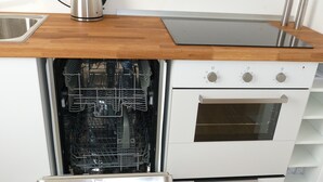 Una cocina con lavavajillas, horno y encimera de madera.