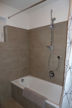 Bañera, secador de pelo, toallas y jabón