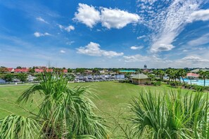 Uitzicht op een resort met een grasveld, een zwembad en een verafgelegen watertoren.