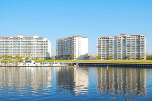 Ein Hotel am Wasser mit mehreren Hochhäusern, einer Marina voller Boote und einem klaren, blauen Himmel.