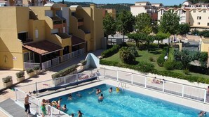A swimming pool surrounded by a white fence, with people swimming and sunbathing. - Studio cabin with pool, sleeps 4, Gruissan (Gruissan)
