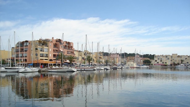 A marina with boats docked, buildings with balconies, and a calm water surface reflecting the structures. - Studio cabin with pool, sleeps 4, Gruissan (Gruissan)