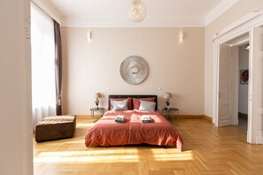 Une chambre spacieuse avec un grand lit, un élément de décoration circulaire au mur et un plancher en bois.