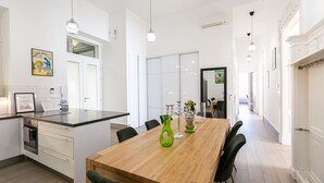 Eine moderne Küche mit einem Holztisch, Stühlen und einer grünen Vase.