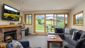 Un salón amplio con chimenea, un televisor de pantalla plana grande, un sofá cómodo y una mesa de comedor.