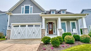 A two-story house with a garage, a front porch, and a well-maintained lawn. - Coastal Club * Ultimate Game Room w/ Resort-Style Amenities (Lewes)