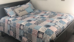 A bedroom with a bed, a ceiling fan, and wall-mounted artwork. - Fully Fenced in Backyard, 1 block to the beach, Golf Cart included, (Myrtle Beach)