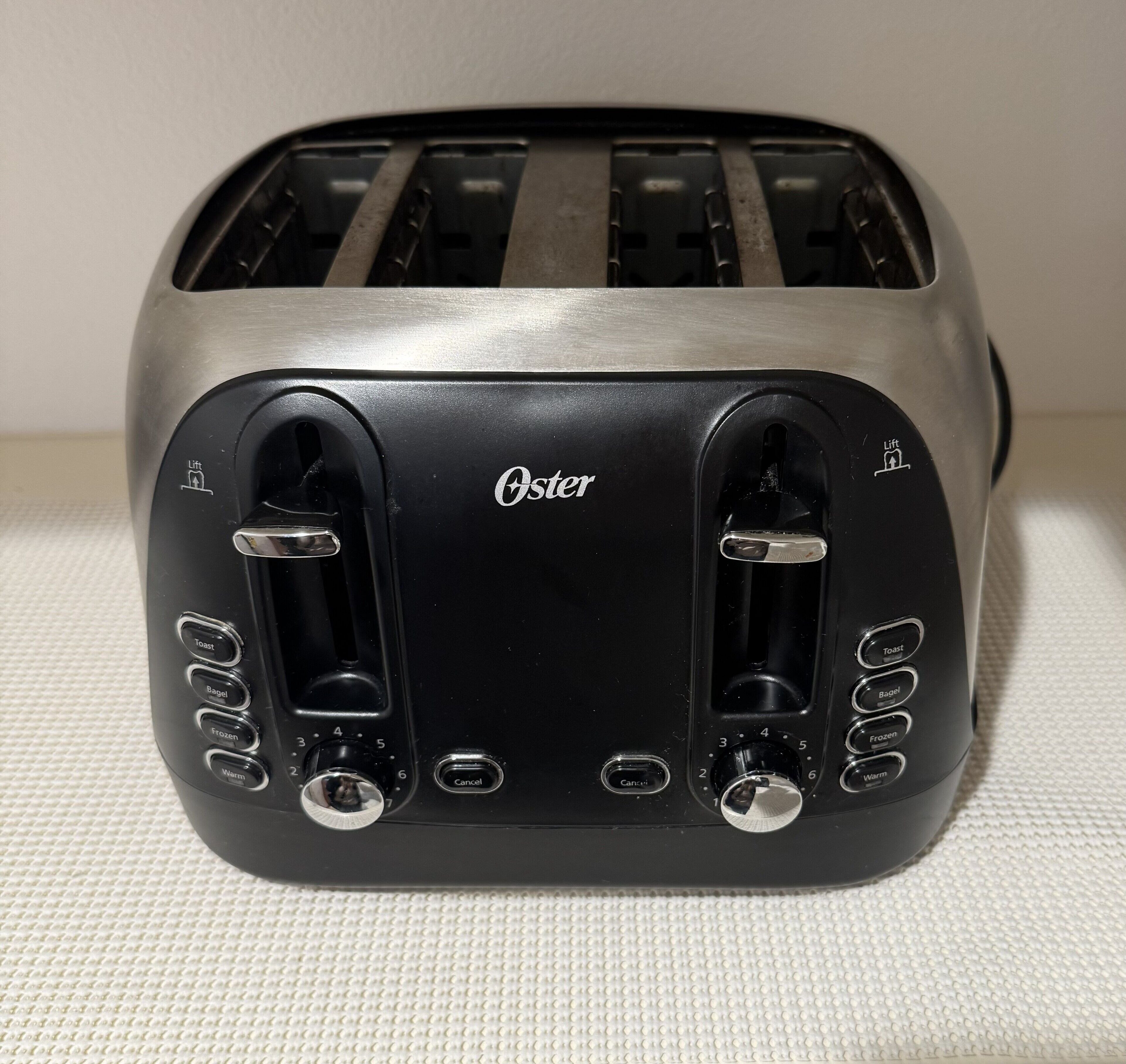 Ein Toaster mit schwarzem Vorderteil und dem Markennamen 'Oster'.