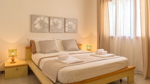 A neatly arranged bedroom with a bed, two bedside tables, and wall art. - Blue Wood Apartment (Letojanni)