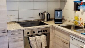 Ett modernt kök med spis, ugn och diskmaskin.