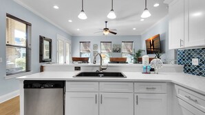 A modern kitchen with white cabinetry, a dishwasher, a sink, pendant lights, and a ceiling fan. - 3 Kings👑Lagoon Pool-Beach Shuttle-2 Living Rms-5BR A Wave Away (Destin)