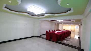 Uma sala de conferências com uma mesa comprida e cadeiras, um candelabro e piso de azulejos.