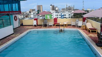 Una piscina al aire libre, sillones reclinables de piscina