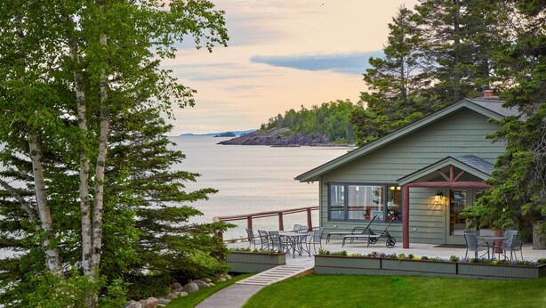 A lakeside cabin with a deck, outdoor seating, and a view of the water. - 'Reflections' Cabin on Lake Superior - Near Lutsen (Schroeder)