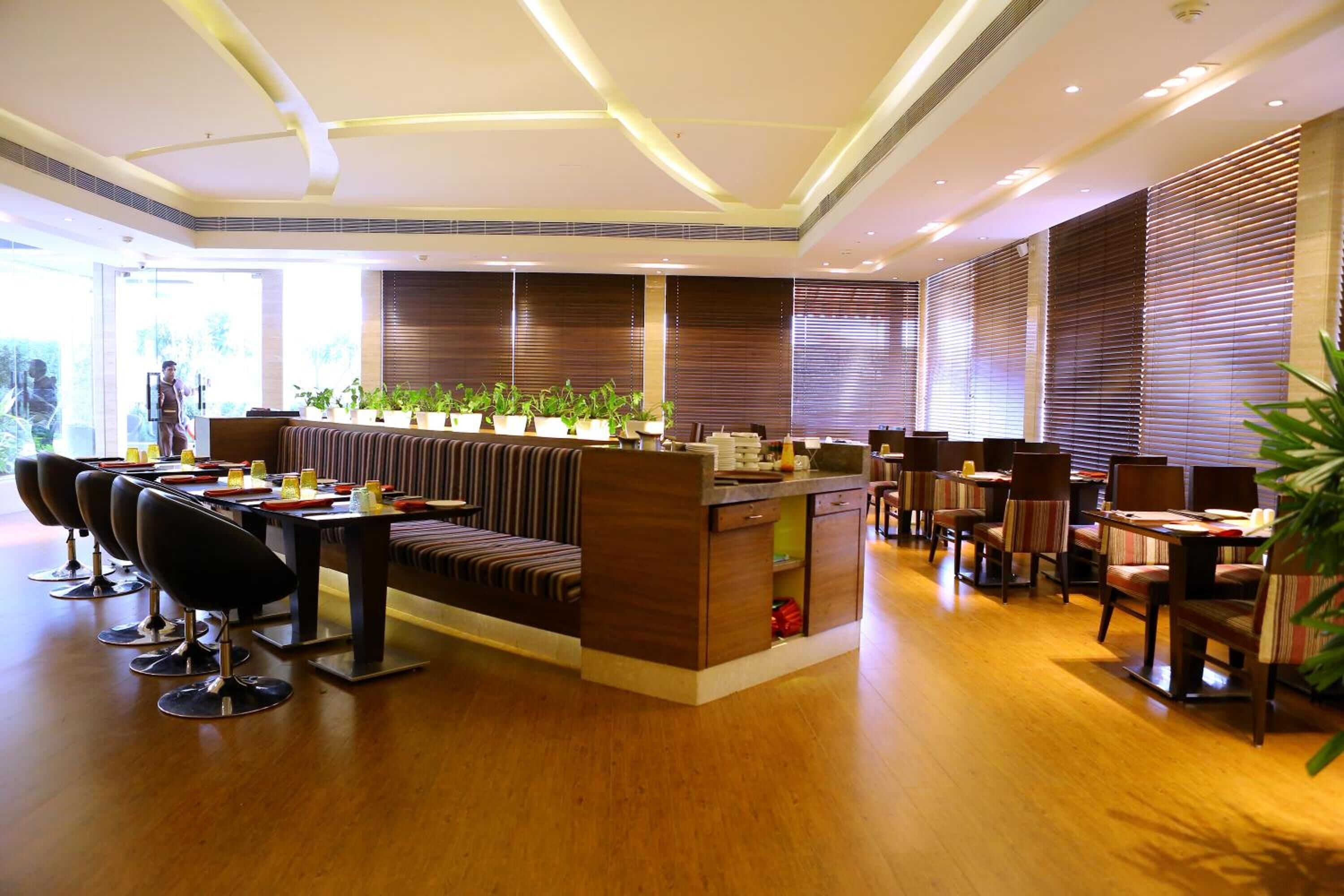 Un moderno vestíbulo de hotel con recepción, área de estar y comedor.