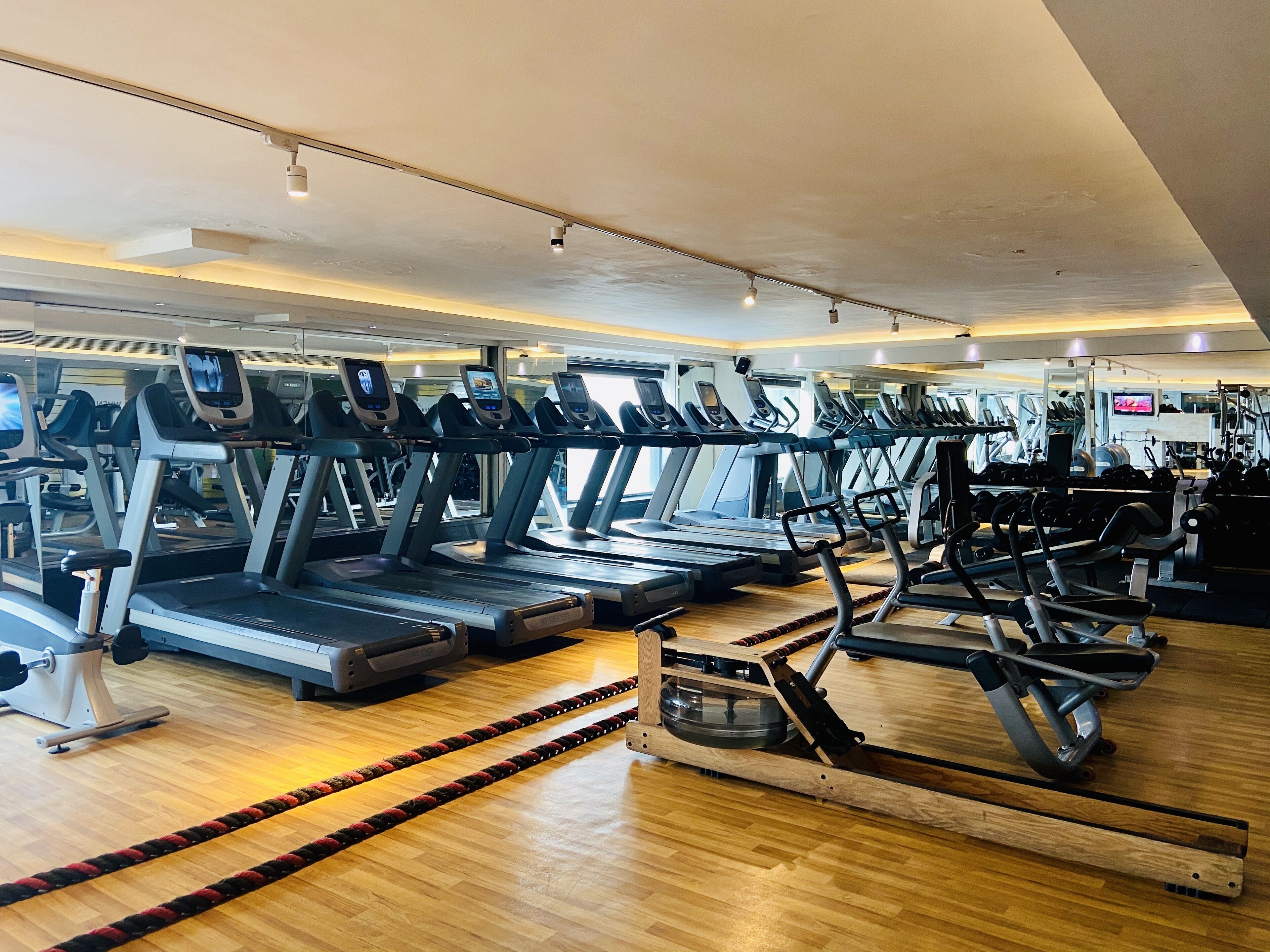 A gym with multiple treadmills, exercise bikes, and weight machines.