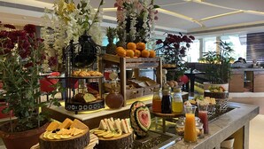 A buffet with various food items, including sandwiches, pastries, and a watermelon with a heart design. - The Landmark Hotel (Kanpur)
