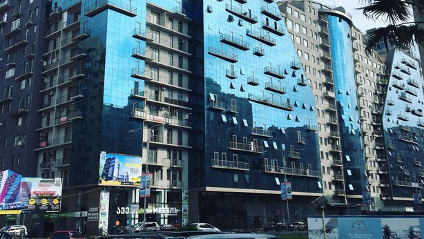 A modern high-rise building with multiple balconies and a glass facade. - Hotel Guesthouse Lola (Batumi)